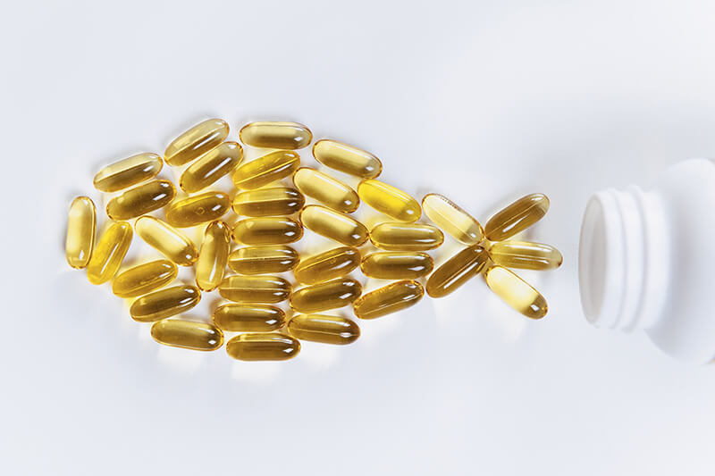Natural Anti-Inflammatory Options for Animals Fish oil capsules and a bottle of fish oil, a natural source of omega-3 fatty acids for a healthy lifestyle.