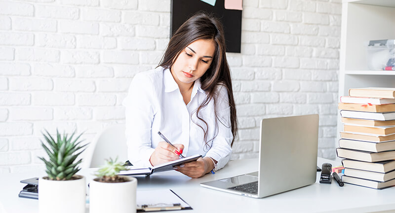 Continuing Your Education: Building Your Animal Expertise A woman sitting at a desk with a laptop and a notebook.
